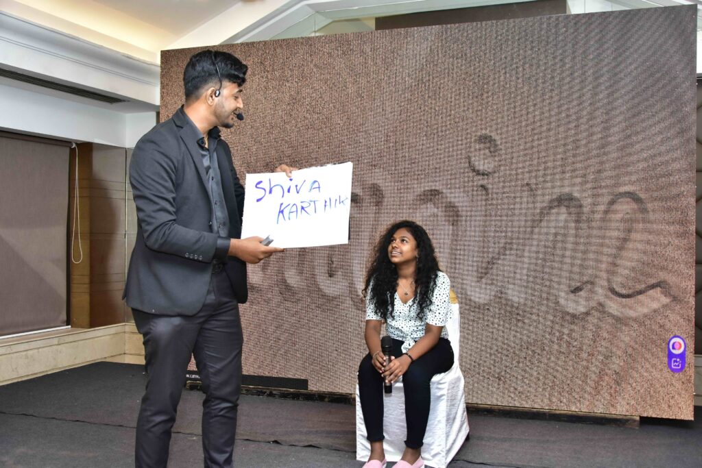 Corporate mentalist performing at a vibrant corporate event, engaging a captivated audience with mind-reading tricks and interactive entertainment.